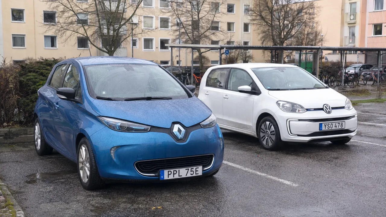 Renault Zoe och Volkswagen e-Up på en våt bostadsparkering.