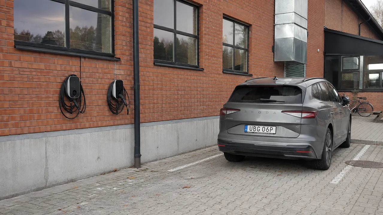 Laddboxar på en tegelvägg vid en arbetsplats med en Škoda Enyaq intill.