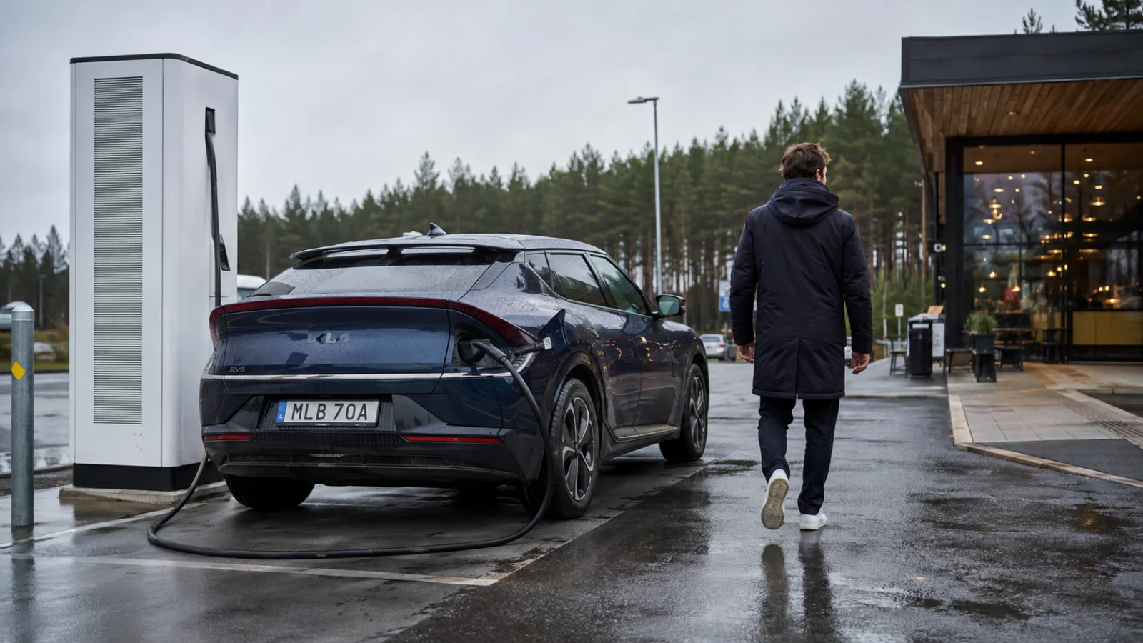 Förare lämnar en inkopplad elbil vid en snabbladdare